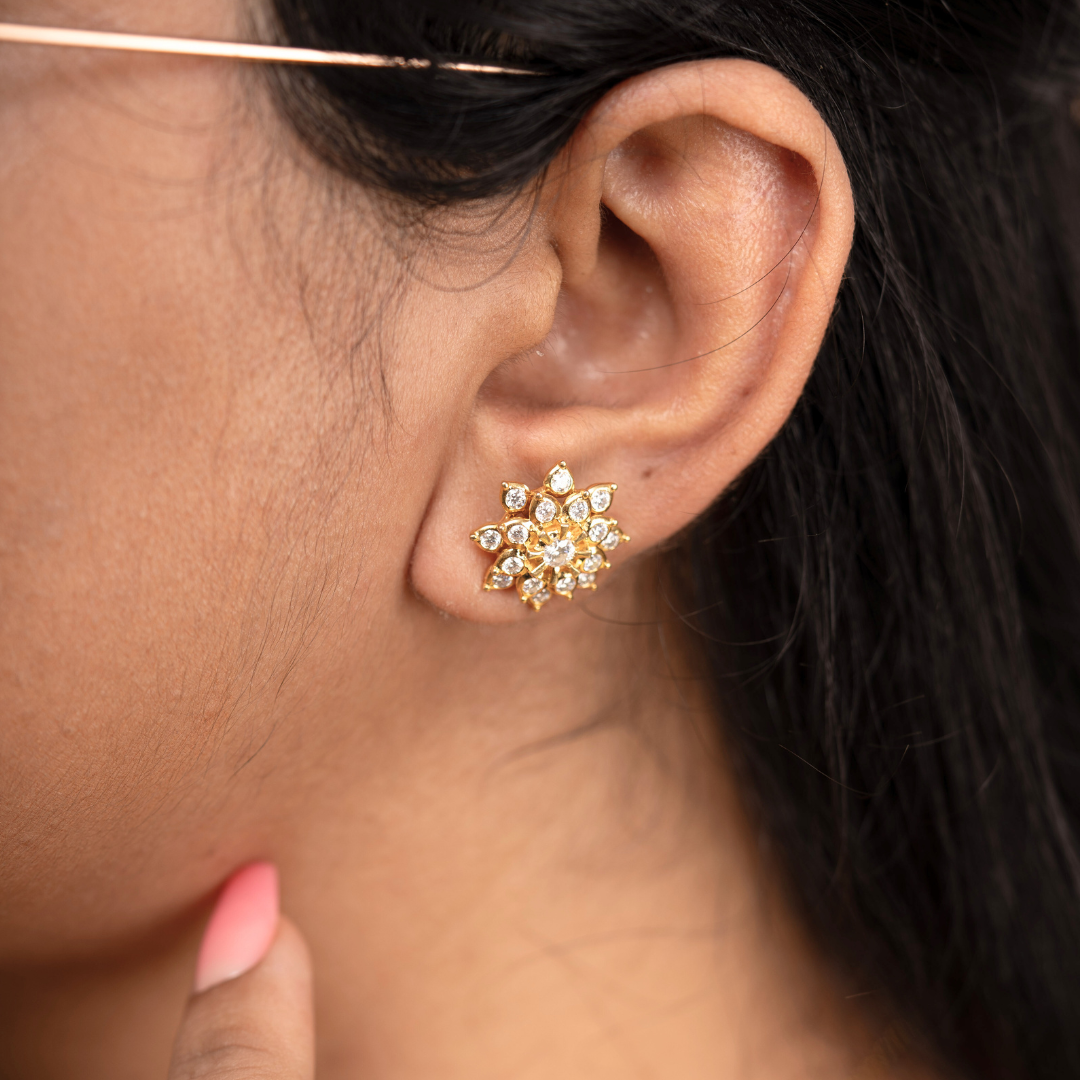 Close-up of an ear wearing a gold and diamond earring.