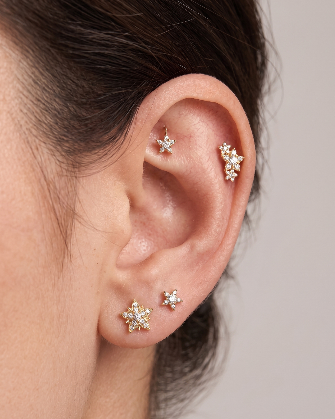 Gold star-shaped earring with clear Moissanite gemstone on a white background by Vai Ra for helix piercing