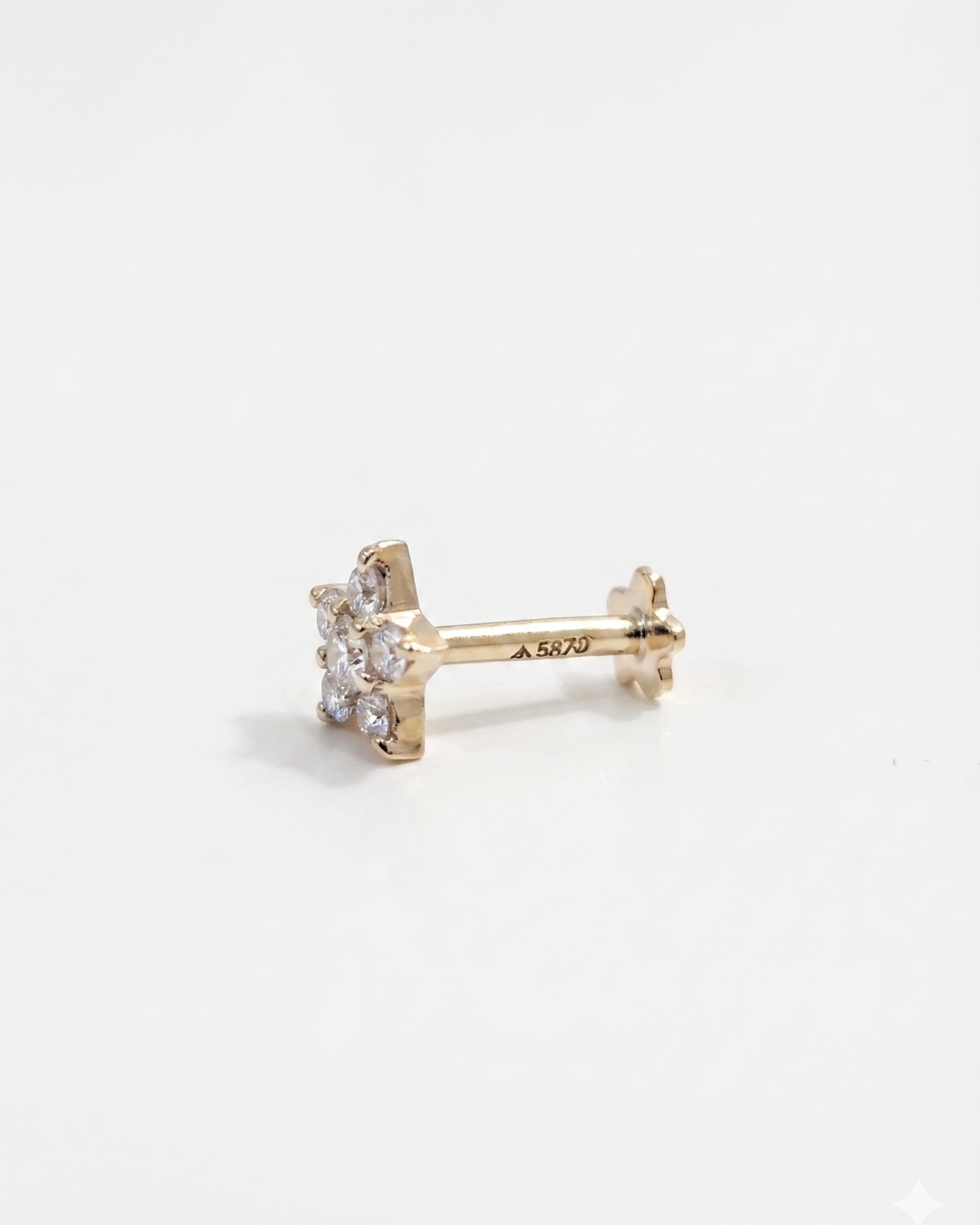 Gold star-shaped earring with clear Moissanite gemstone on a white background by Vai Ra for helix piercing