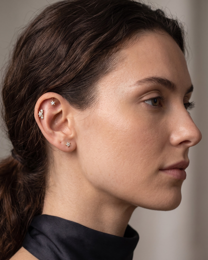 Gold star-shaped earring with clear Moissanite gemstone on a white background by Vai Ra for helix piercing